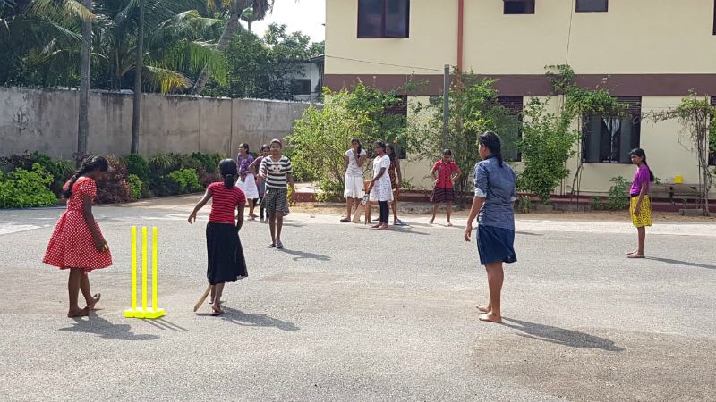 Girls playing cricket in the playground